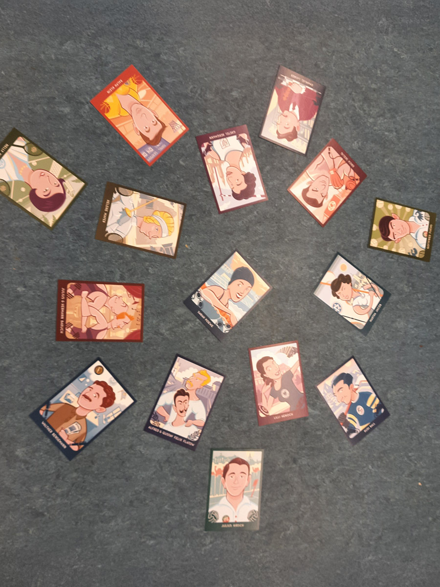 Spielkarten auf einem grauen Fußboden verteilt. Darauf illustrative männliche und weibliche Sportstars der Zeitgeschichte