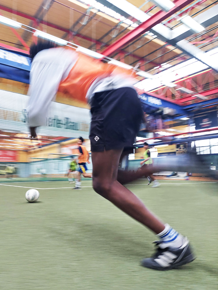 Action-reiches Motiv eines Ball-Spielers in einer Halle. Durch die schnelle Bewegung ist das Bild in Unschärfe festgehalten